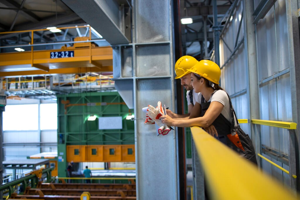 factory workers talking in production hall.